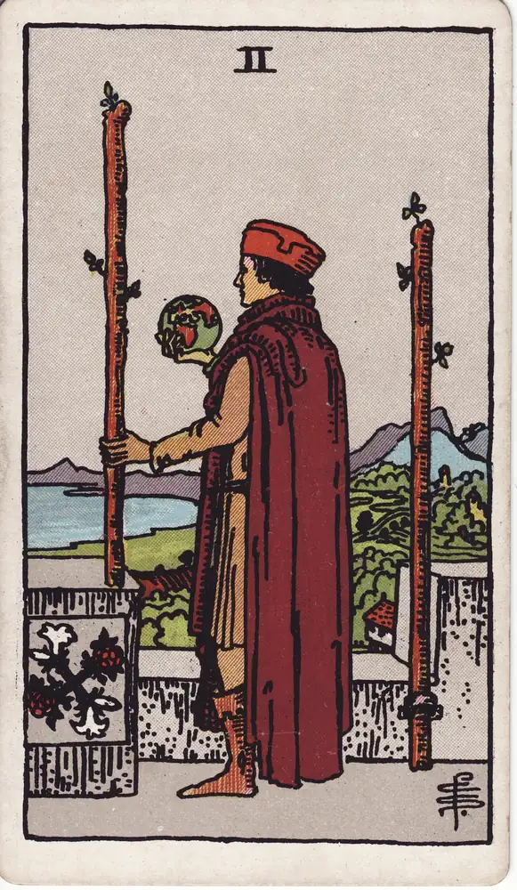 Karta tarota „Dwójka Buław tarot – znaczenie karty Two of Wands” z talii Rider–Waite–Smith.